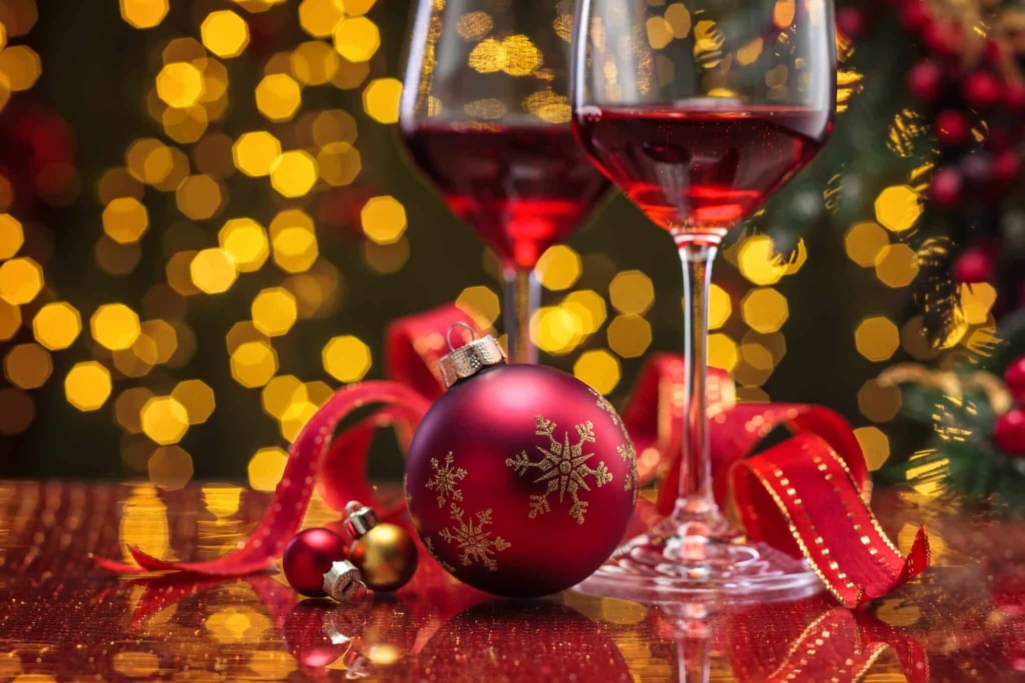 red wine with christmas decorations laying next to it