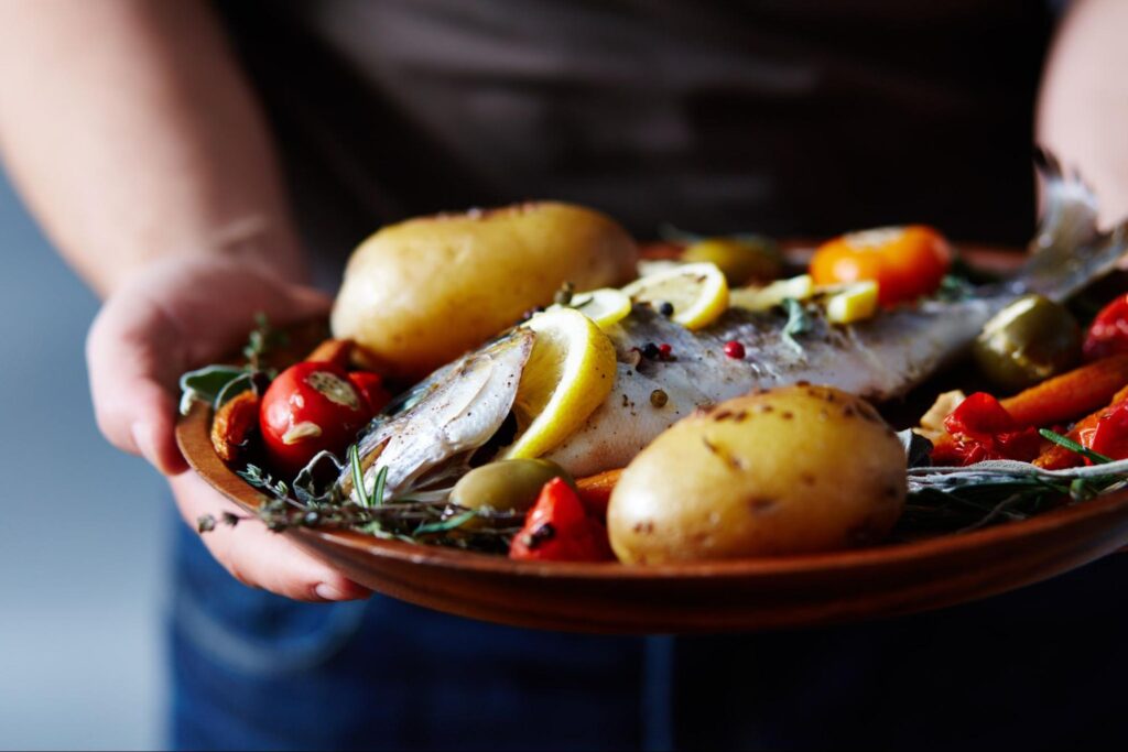 baked trout with vegetables on plate