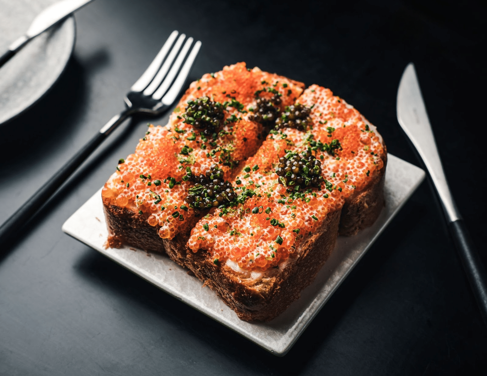 caviar toast with silver laying on the table 