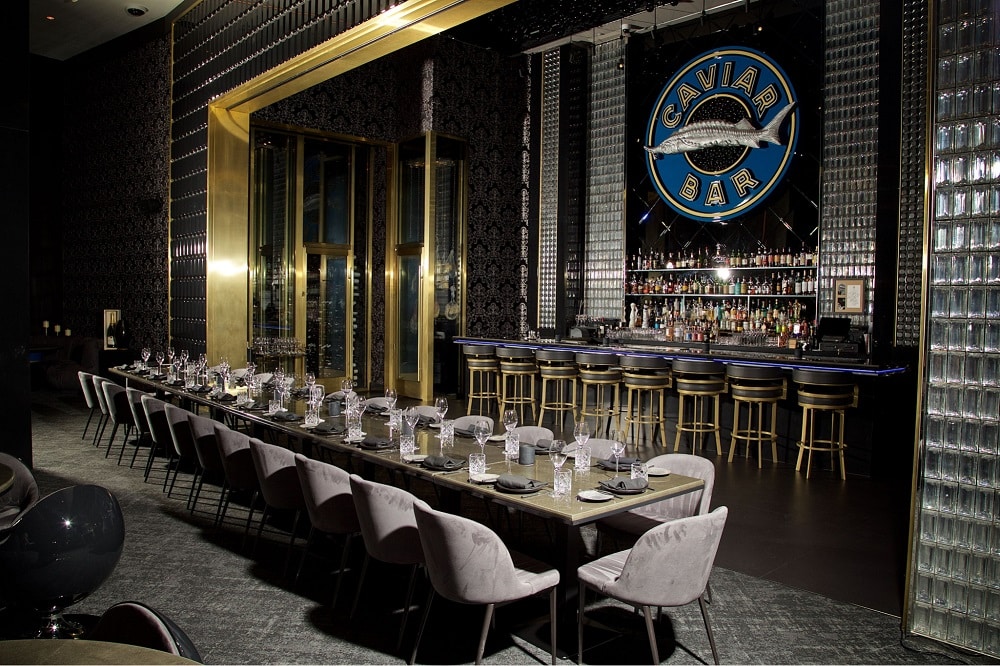 An image of a group dining table set up in front of the bar at Aqua Seafood & Caviar Restaurant.