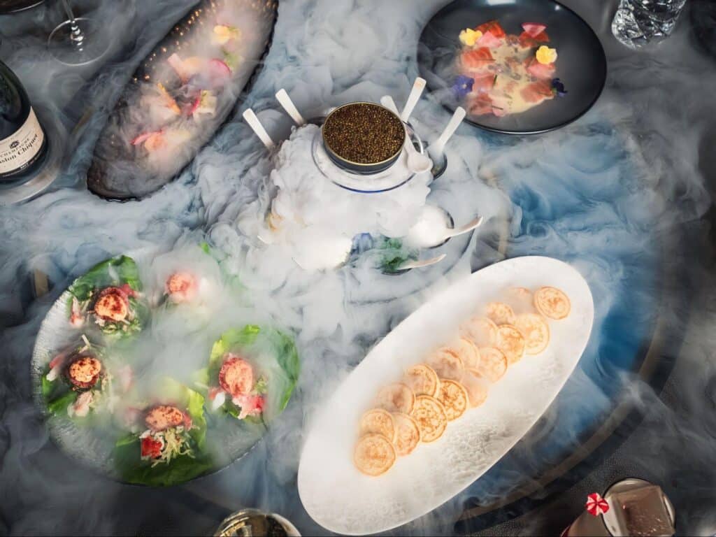 Food with dry ice surrounding it from Aqua Seafood & Caviar Restaurant.