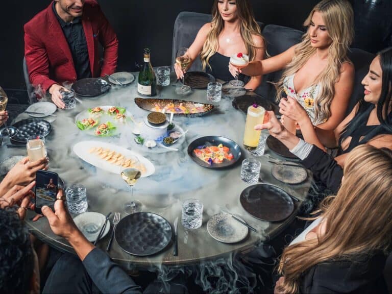 A group of people eating dinner at Aqua Seafood & Caviar Restaurant.